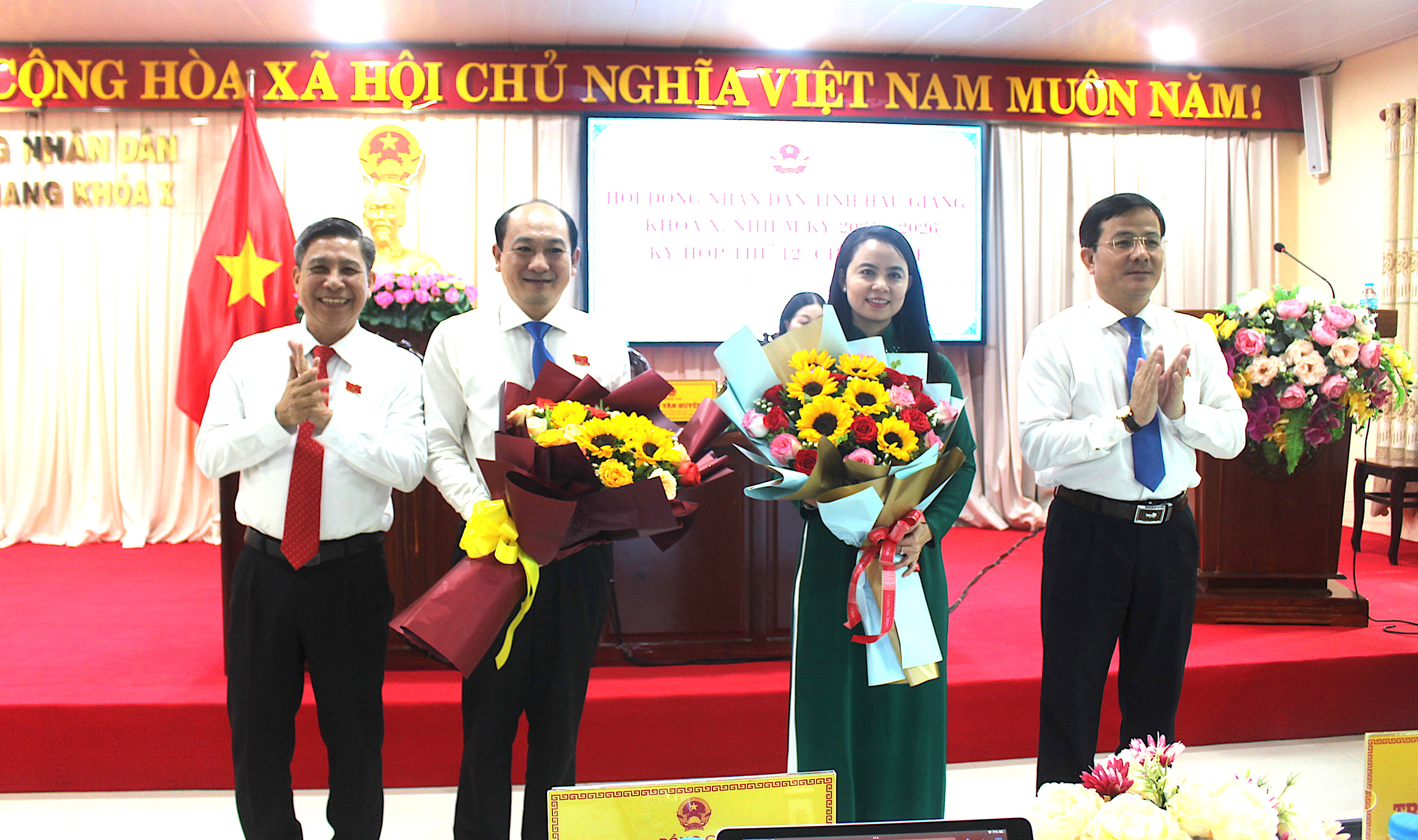 Đồng chí Võ Thị Mỹ Trang và đồng chí Trần Thanh Lâm (giữa) nhận hoa chúc mừng từ lãnh đạo tỉnh.